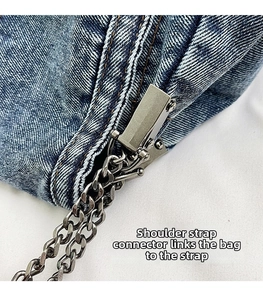 Detail view of the metal chain strap and sturdy buckle on blue denim shoulder bag