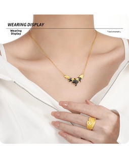 Close-up of elegant irregular leaf pendant and lava texture ring worn by model