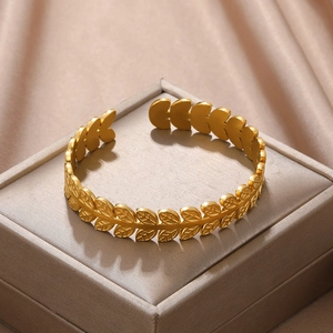 Macro detail of golden olive leaf open bangle with intricate leaf vein texture details