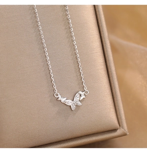 Macro shot of silver butterfly pendant with micro-pave zircons on a jewelry box