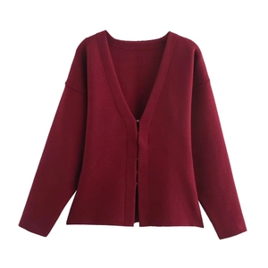 Détails du cardigan en maille rouge foncé montrant la texture fine et le col en V