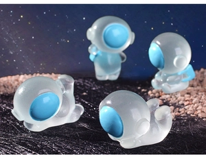 Set of 4 glowing resin astronaut figurines on starry cosmic space surface
