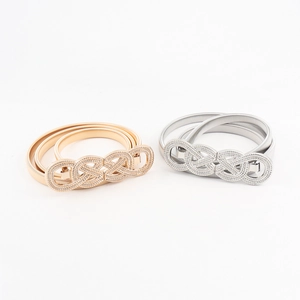Detail of gold and silver elastic metal belts with minimalist twist knot buckles