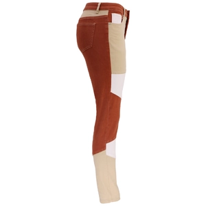 Dettaglio dei jeans a vita alta con design color-block marrone e beige e cuciture laterali