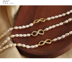 Detail of 18k gold infinity charms with zircons on freshwater pearl beaded bracelets
