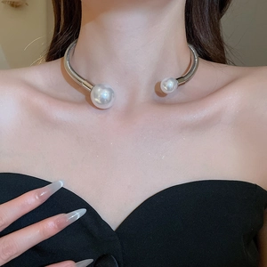 Close-up of metallic pearl choker necklace showing silver tube design on model's neck
