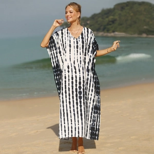 Close-up of white knit beach kaftan with black tie-dye stripes and loose fit texture