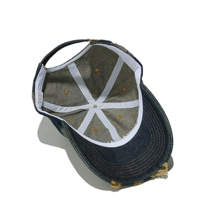 Dettaglio interno del berretto da baseball in denim vintage con etichetta 100% cotone