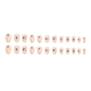 Short oval press-on nails set with gold foil stars, moon patterns and purple glitter