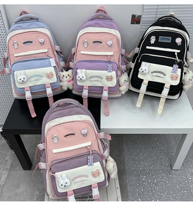 Detailed display of assorted colorful school backpacks with cute plush pendants and badges