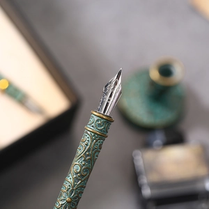 Macro shot of an antique bronze quill pen nib with intricate vintage embossed patterns