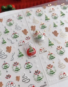 Macro view of 3D embossed Christmas nail stickers with tree and snowflake patterns