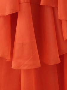 Gros plan détaillé de volants en mousseline orange rouge avec une texture légère et fluide