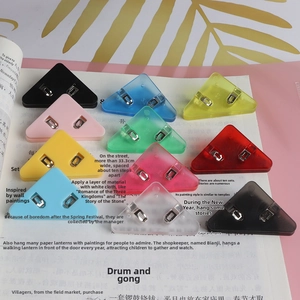 Macro view of colorful triangular corner paper clips on open book pages for organization