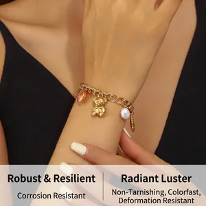 Vue détaillée d'un bracelet doré à double chaîne avec charms d'ours et de perles