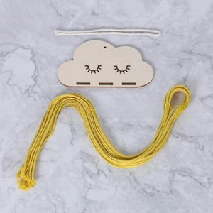 Detailed view of cloud-shaped wooden wall decor with yellow tassel and cute face
