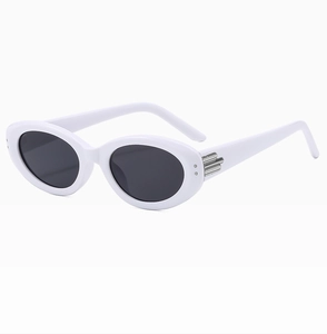 Detail of white oval sunglasses frame with silver metal accents and dark lenses