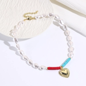 Detailed shot of baroque pearl necklace with colorful beads and gold heart charm