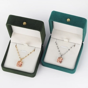 Detail of pink crystal pendants in gold and silver finishes on velvet jewelry boxes