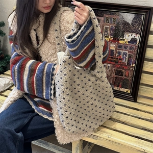 Detail of cream fleece tote bag with blue hearts shown in a cozy autumn setting