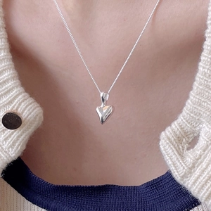 Close-up of minimalist 925 sterling silver irregular heart necklace on a model