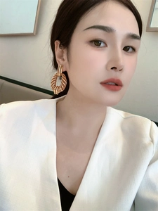 Close-up of 18K gold-plated oversized hoop earrings with spiral zebra texture on model
