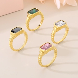 Set of four gold-tone twisted rings with emerald-cut stones in green, black, and pink