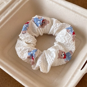 Detail of white quilted scrunchie featuring cute cartoon bear pattern and lace trim
