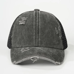 Close-up of distressed washed denim baseball cap with mesh back and torn edge details