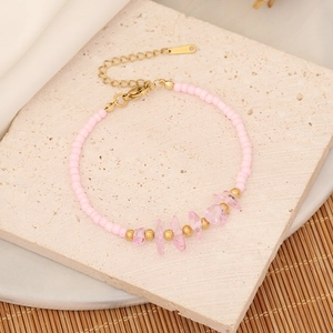 Detailed macro view of pink beads, crystal stones, and gold steel clasp on the bracelet