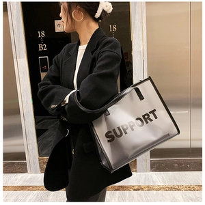 Detail view of the transparent PVC tote bag with black leather trim and SUPPORT text