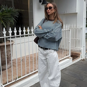 Detail of blue and black striped long sleeve t-shirt styled with white trousers