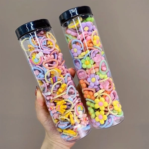 Close-up of colorful cartoon hair ties for girls in jars featuring stars and rainbows