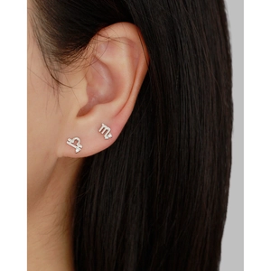 Close-up of S925 sterling silver Libra and Scorpio zodiac stud earrings with white zircons