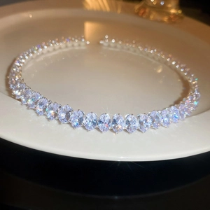 Macro shot of an oval-cut zircon tennis necklace on a white ceramic plate