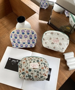 Detailed macro view of quilted cotton makeup bags with floral and cherry patterns