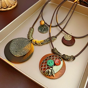 Détail de colliers en cuir vintage avec pendentifs en bois et éléments en métal vieilli