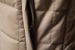 Macro detail of khaki ripstop fabric with square quilting and durable metal zipper