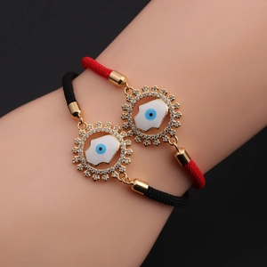 Detail of adjustable woven evil eye and hamsa bracelets with gold zircon pendant