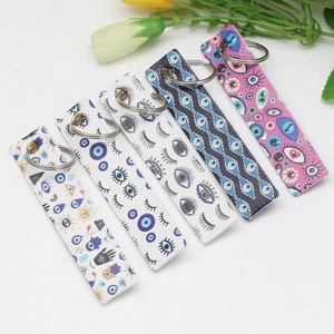 Five assorted evil eye printed webbing keychains with durable metal rings on white background