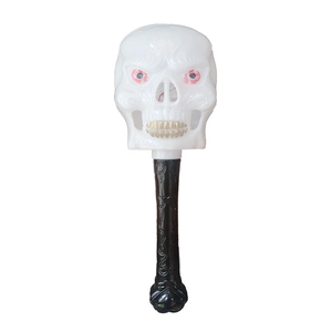 Close-up of a glowing Halloween skeleton wand toy with golden teeth and red eyes details