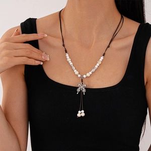 Close-up of ethnic beaded necklace with ceramic butterfly pendant and silver fish charms