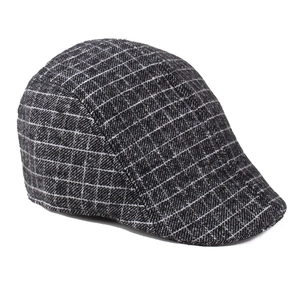 Close-up of gray plaid wool texture on a classic British style newsboy cap