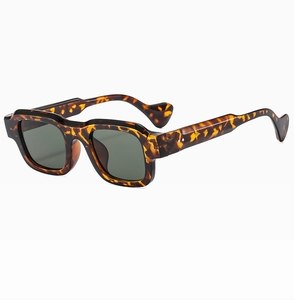Detail of square tortoiseshell sunglasses with dark green lenses and reinforced rivets