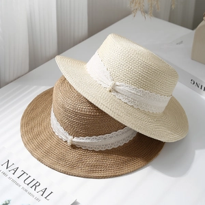 Flat top straw sun hats with elegant lace ribbons and pearl accents for beach holidays