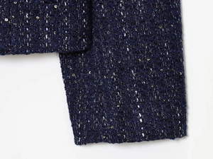 Detaillierte Makroansicht von marineblauem Tweed mit schimmernden Pailletten am Ärmel
