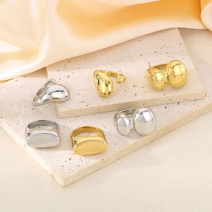 Collezione di anelli irregolari in oro e argento su pietra con elegante tessuto di raso