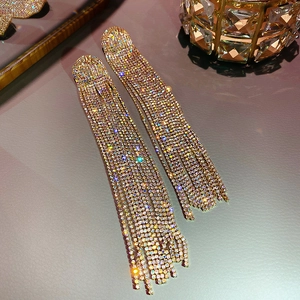 Macro detail of silver drop earrings with long rhinestone tassels in a luxury setting