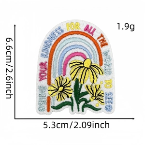 Macro detail of rainbow and daisy embroidered patch with inspirational quote for DIY bags