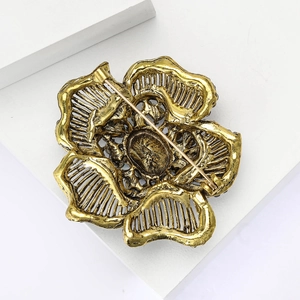 Detailed back view of vintage gold flower brooch showing hollow alloy structure and pin